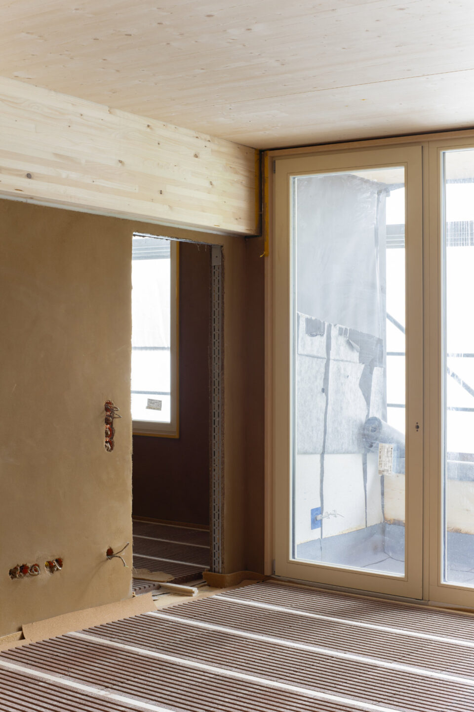 Haus A (Holzbau): Lehmtrockenbauwand an Außenwand und reversible Trockenestrichelemente | Foto: Arge ZRS Architekten & Bruno Fioretti Marquez